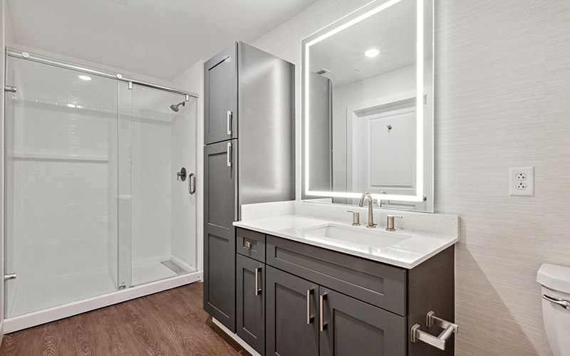 bathroom with shower and large mirror